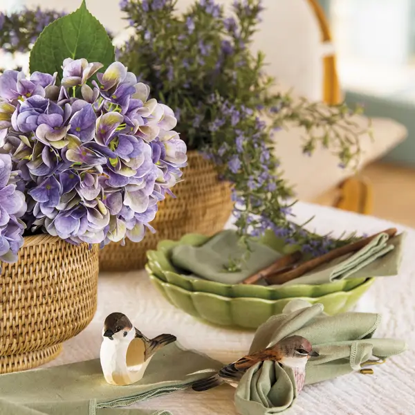 Mesa de comedor romántica con vajilla verde y flores violeta